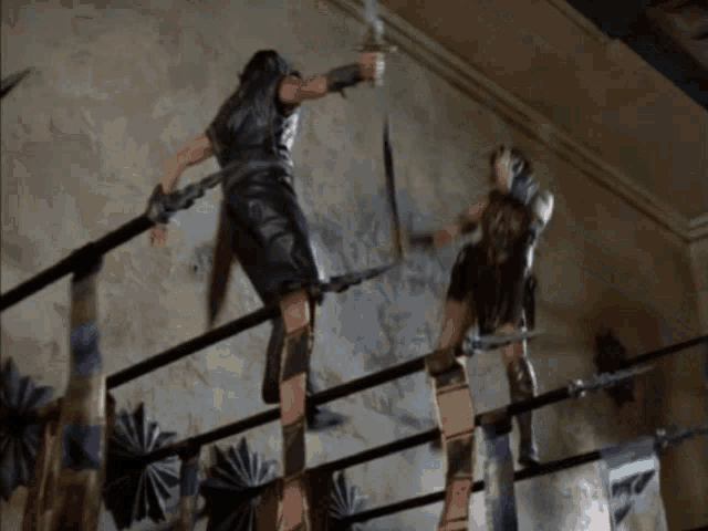 a man and a woman are fighting with swords in a boxing ring