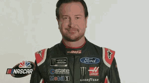 a man is wearing a ford racing suit and smiling