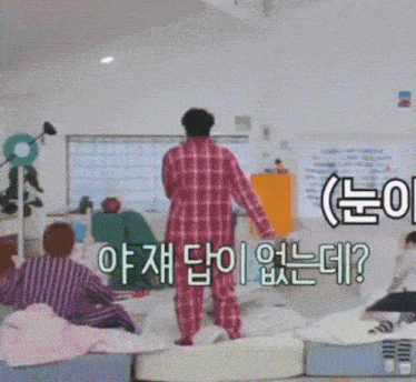a man in a plaid shirt is standing in a room with asian writing