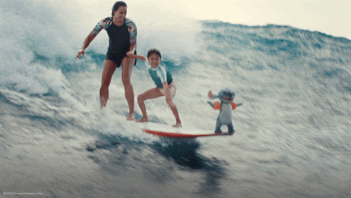a woman and child are riding a wave on a surfboard while a stuffed animal looks on