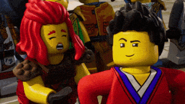 a group of lego figures are standing next to each other and one of them has red hair