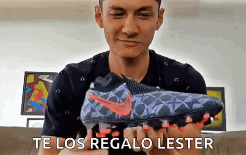 a man is holding a pair of nike soccer cleats in his hands and says te los regalo lester