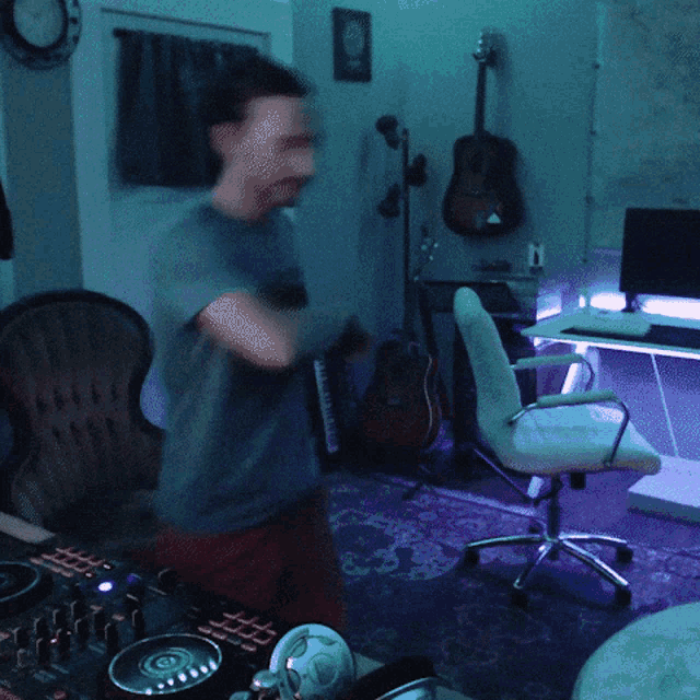 a woman is dancing in a room with a dj mixer