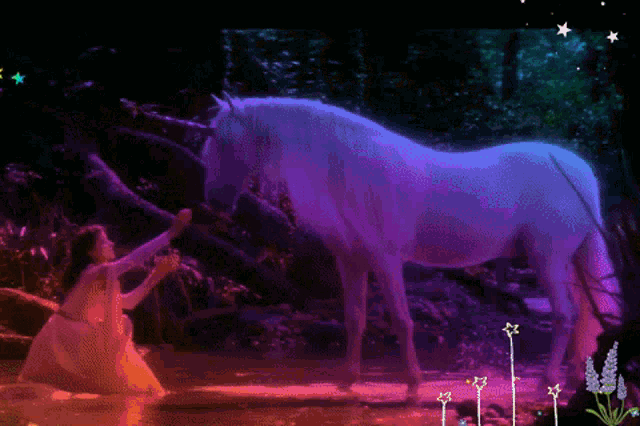 a woman kneeling next to a unicorn in a pond