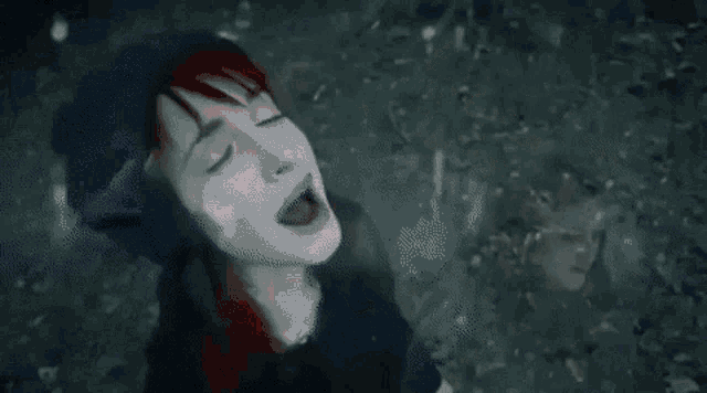 a woman with red hair and a blue hat is singing .