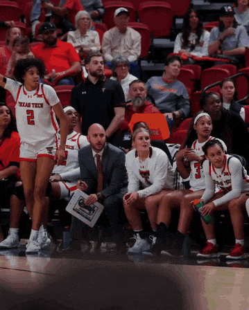 a texas tech basketball player stands in front of a crowd of people