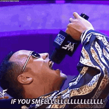 a man is singing into a microphone with the words if you smell