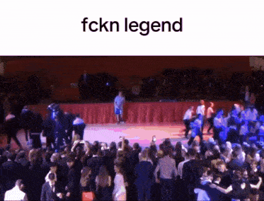 a large group of people are dancing in a room with the words fckn legend written above them