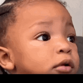a close up of a baby 's face with his mouth open .