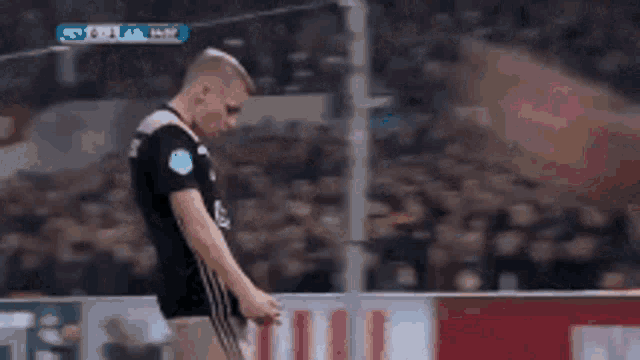 a soccer player with crutches is walking on the field .