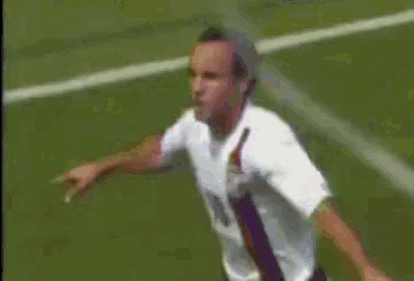 a man in a white shirt is standing on a soccer field
