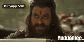 a man with long hair and a beard is holding a sword in his hand .