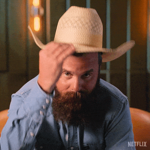 a man with a beard is wearing a cowboy hat and a netflix logo