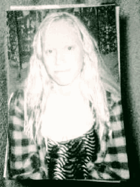 a black and white photo of a young woman with long blonde hair .