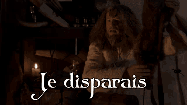 a man with a beard is sitting in front of a candle and the words je disparais