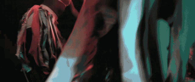 a blurry picture of a person 's torso with a red and blue background
