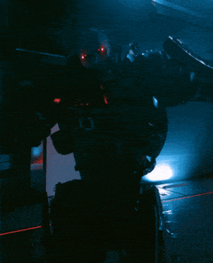a robot in a dark room with a red light shining on it