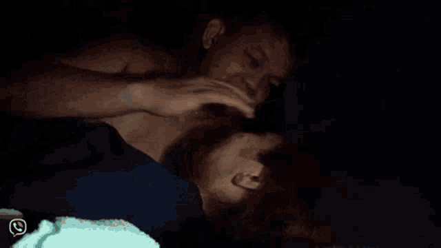 a man and a woman are kissing in the dark .