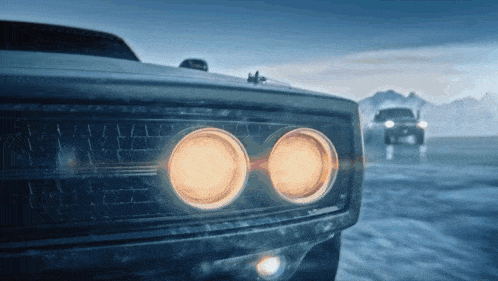 a close up of a car 's headlights with a mountain in the background