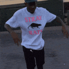 a man wearing a shirt that says stray rats on it