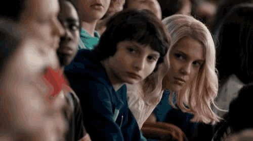 a group of people are sitting in a row and looking at something
