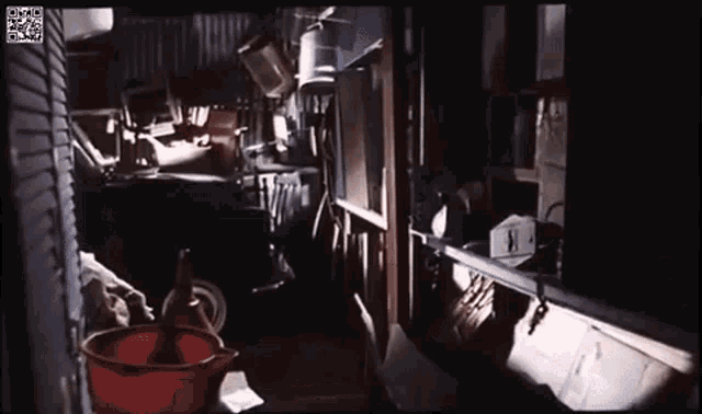 a dark room with a red bucket on the floor
