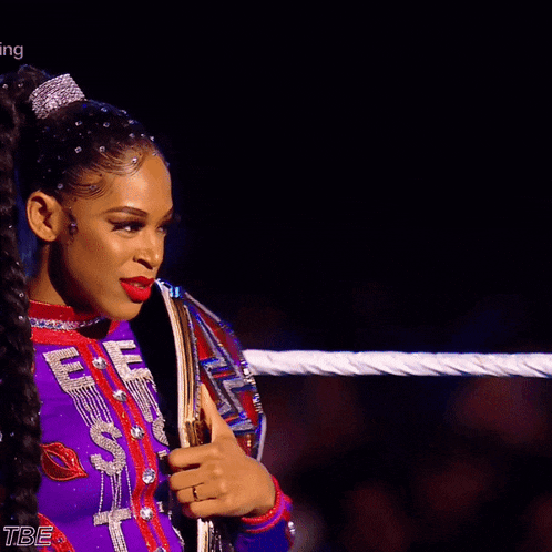 a woman in a purple outfit holds a wrestling championship belt that says ufc