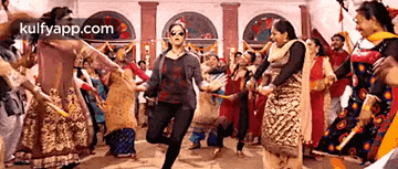 a woman is dancing with a group of people in a room .