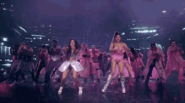 a woman in a pink outfit is surrounded by other women