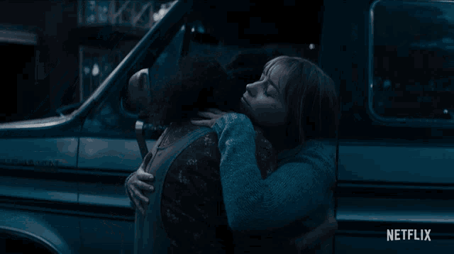 two women hugging in front of a car that says netflix on the bottom