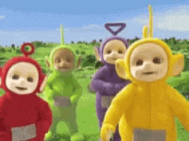 a group of teletubbies are standing in a grassy field