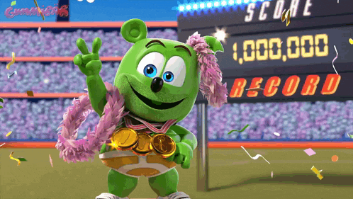 a gummy bear wearing a medal around his neck is standing in front of a scoreboard that says 1,000,000 record