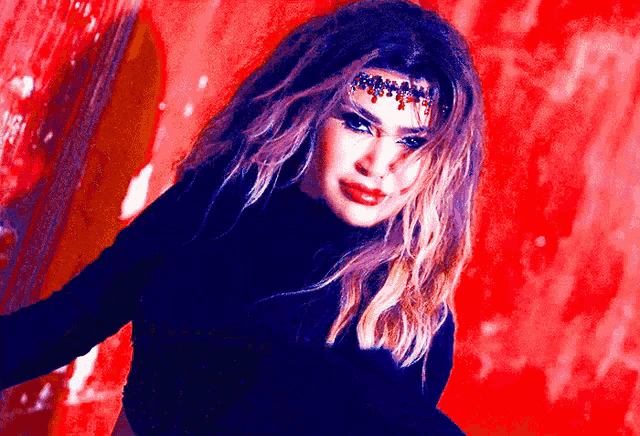 a woman wearing a black sweater and a headpiece with red beads