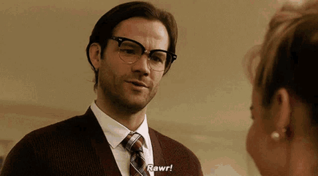 a man wearing glasses and a sweater says rawr