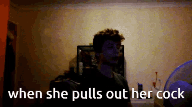 a man standing in a dark room with the words when she pulls out her cock