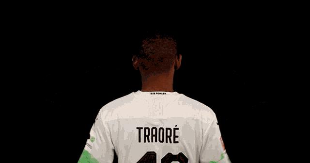 a man wearing a white shirt with the name traore on it