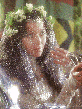 a woman is wearing a veil and a flower crown