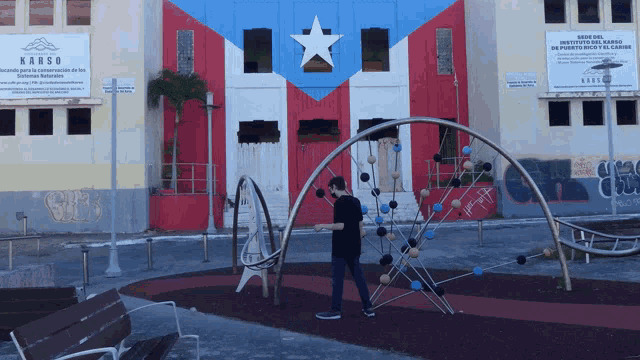 a man standing in front of a building that says karso on it