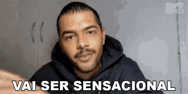 a man with a beard and mustache is wearing a black hoodie and says vai ser sensacional .
