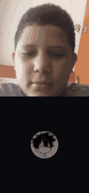 a young boy is sitting in front of a computer screen with a picture of a cartoon character on it .