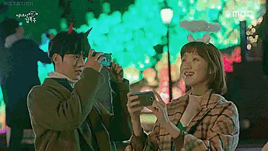 a man and a woman are taking a picture of each other with their cell phones .