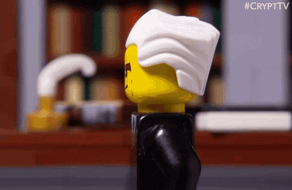 a lego figure is standing in front of a bookshelf with the hashtag #crypttv at the bottom
