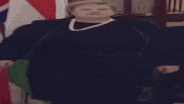 a very fat woman is walking in front of flags .