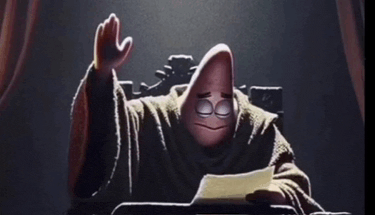 patrick star from spongebob is sitting at a desk with his hand up