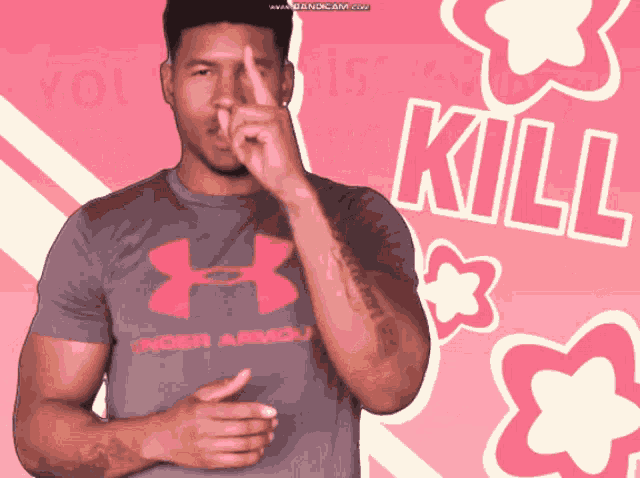 a man wearing a grey under armour shirt is making a funny face