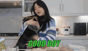 a woman is hugging a dog in a kitchen with the words good boy written on the bottom