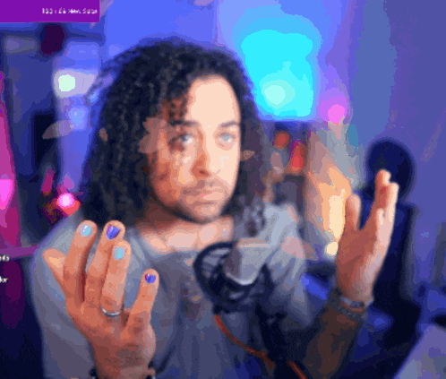 a blurry picture of a man with purple nails and a ring on his finger