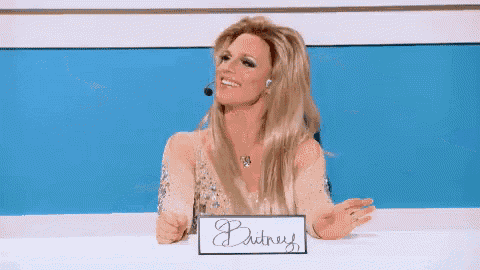 a woman sitting at a table with a sign that says britney on it