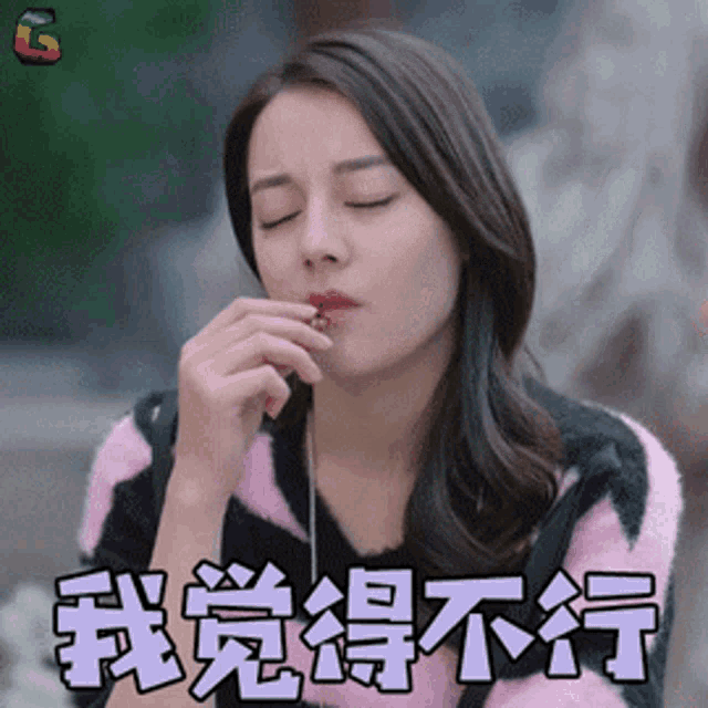 a woman in a pink and black striped sweater eating something