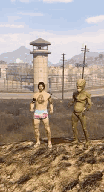 a man and a statue are standing on top of a hill in front of a prison tower .